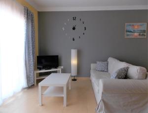 科蒂略Family Heaven - No Stress Holidays的客厅配有沙发和墙上的时钟