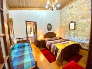 PenedoCasa do Outeirinho- Turismo Rural的一间卧室设有一张床和石墙
