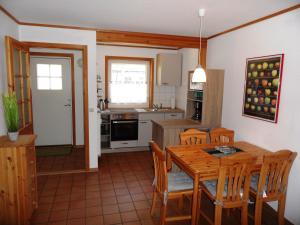 黑灵斯多夫ökologische Ferienanlage的厨房以及带木桌和椅子的用餐室。