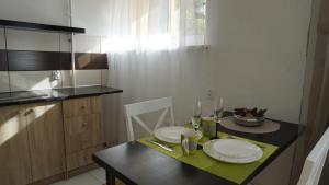 利耶帕亚LEA Apartments的小厨房配有带盘子和玻璃杯的桌子