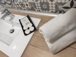 庞特维德拉Hospédate Pontevedra的浴室水槽上备有毛巾和两块纸杯蛋糕