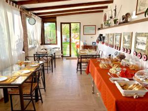 贾迪尼-纳克索斯B&B Villa Vittoria的餐厅配有长桌子和椅子,提供食物