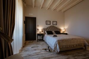 切法卢Donna Carolina Luxury rooms的一间卧室配有一张床、一张桌子和两盏灯。