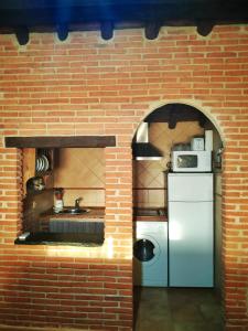 米兰达德尔卡斯塔尼亚尔Casa rural La Villa的厨房配有白色冰箱和砖墙