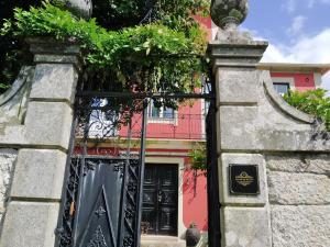 AncedeSolar da Motta Douro Boutique Home的通往粉红色房子的大门,有黑色的门
