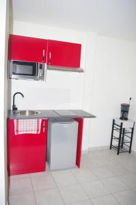 蒙塔日达特尼昂酒店的一间带红色橱柜和水槽的厨房