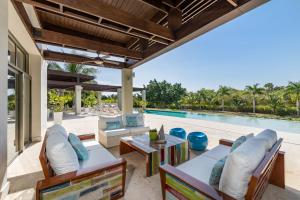 拉罗马纳Unique Private Villa with Pools and Golf Cart的一个带桌椅的户外庭院和一个游泳池