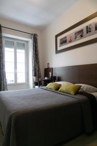 拉兰Hôtel d'Ossau的一间卧室设有一张大床和一个窗户。
