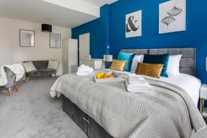 泰恩河畔纽卡斯尔Stylish Apartment in the heart of Newcastle centre的一间卧室配有一张带蓝色墙壁的大床