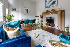 泰恩河畔纽卡斯尔Stylish Apartment in the heart of Newcastle centre的客厅配有蓝色的沙发和桌子