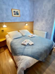 若西耶Hôtel Bel'Air的一间卧室配有一张床,上面有两条毛巾