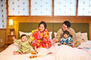 高山本阵平野屋花兆庵酒店的和两个婴儿一起坐在床上的家庭