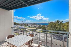 尼尔森湾地标度假胜地酒店的阳台配有桌椅,享有海景。