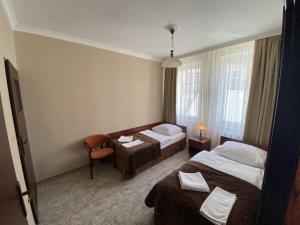 乌斯特卡Hotel Morze的酒店客房,配有两张床和椅子