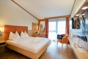 巴德瓦尔特斯多夫巴德瓦尔特斯多夫温泉科伦酒店的酒店客房设有一张大床和一张书桌。