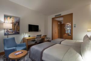 伊斯坦布尔图兹拉湾伊斯坦布尔假日酒店 的酒店客房配有一张床、一张桌子和一把椅子。