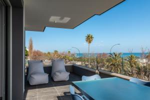 圣贝内代托-德尔特龙托Karma Resort的阳台配有蓝色的桌椅和海洋