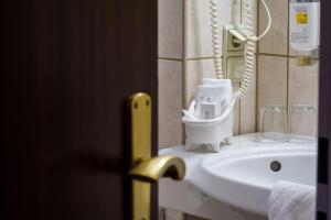 赖因贝克瑞比克萨彻森瓦尔德酒店的一间带白色水槽的浴室和一部电话