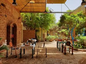 瓦加杜古Villa Yiri Suma的户外庭院配有桌椅和树木。