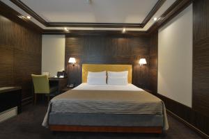 诺维萨德Garni Hotel Aleksandar的一间卧室配有一张床、一张桌子和一张四柱床。