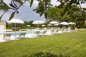 博尔加涅La Casina Di Borgagne的游泳池旁的一排椅子和遮阳伞