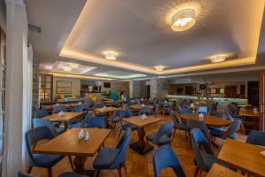 阿里奥波利斯城堡海麦尼酒店的餐厅设有木桌和蓝色椅子