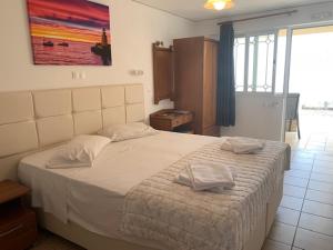 卡西奥皮Kassiopi Bay的一间卧室配有一张大床和两条毛巾