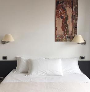卡德泽特拉洛坎达酒店的一张带两盏灯的白色床和上面的绘画