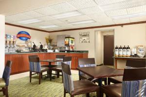 苏福尔斯苏福尔斯贝蒙特旅馆套房酒店的一间带桌椅的餐厅和一间酒吧