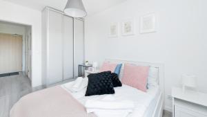 克拉科夫Apartamenty Sun & Snow Konopnicka City的白色的床和粉红色及黑色枕头