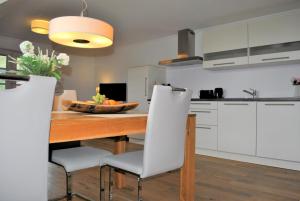 托特瑙贝格Hotel & Chalets Herrihof的厨房配有木桌和白色橱柜。