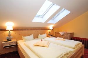 奥巴拉马高Landhotel Böld Oberammergau的卧室配有一张白色大床和天窗