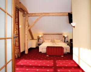 奥巴拉马高Landhotel Böld Oberammergau的酒店客房,配有床和红色地毯