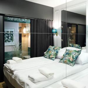 索波特Wave3 - Monte Cassino by OneApartments的卧室配有一张白色大床和镜子墙