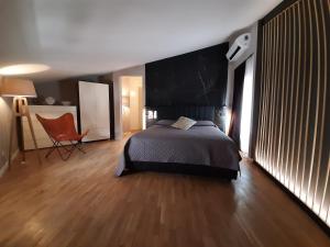 代森扎诺-德尔加达MoAA - Modern Art Apartment的一间卧室配有一张床和一把椅子