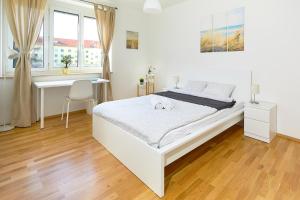 格拉茨Gemütliche Wohnung in zentraler Lage的白色卧室配有床和书桌