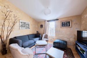 圣艾米隆Elégant appartement tout confort avec climatisation dans le centre historique de ST Emilion的客厅配有蓝色的沙发和电视