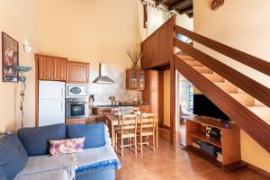 El Pinar del HierroCasa Rural La Pestilla 1的一间带蓝色沙发的客厅和一间厨房