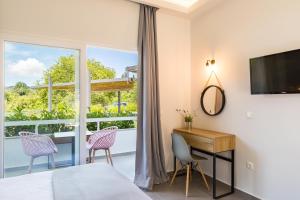 阿普索斯La Maison Corfu - Adults Only的一间卧室配有一张床、一张书桌和一个窗户。