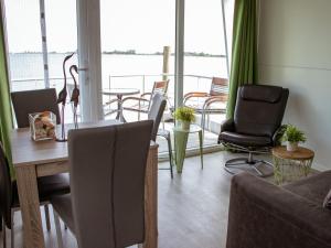 比丁赫伊曾Houseboat uitzicht over veluwemeer, natuurlokatie, prachtige vergezichten的一间带桌椅的客厅和一个阳台