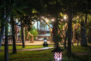 乌鲁瓦图美帝家庭旅馆的草丛中树木和灯光的公园