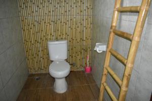 乌鲁瓦图美帝家庭旅馆的一间带卫生间和竹墙的浴室