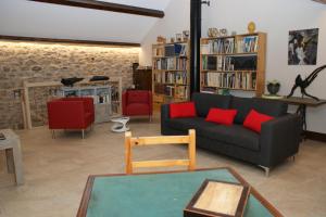 孔佩尔Les FREJALS的客厅配有黑色沙发和红色椅子