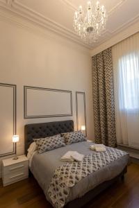 佛罗伦萨瓦伦提诺豪华II酒店的一间卧室配有一张带吊灯的大床