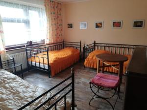 SzczedrzykBiohof Am Turawa-See的一间卧室配有两张床、一张桌子和一把椅子