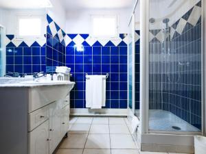 奥普拉图尔酒店的蓝色瓷砖浴室配有淋浴和盥洗盆