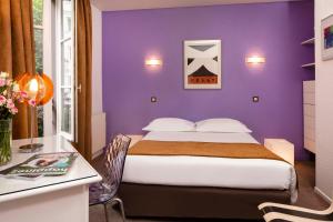巴黎帕西小村酒店的紫色卧室配有一张床和一张书桌