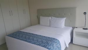 亚松森START Villa Morra Rent Apartments的卧室配有白色床和蓝色棉被