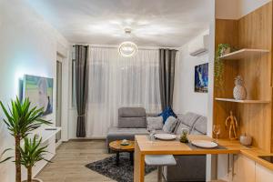 萨格勒布Jacuzzi - Flexible SelfCheckIns 20 - Zagreb - Luxury - Garage - Smart - Brand New - Apartments Repinc的客厅配有桌子和沙发