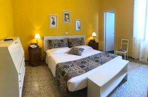 马里纳-迪-皮特拉桑塔Albergo Grande Italia的一间卧室设有一张大床和黄色的墙壁